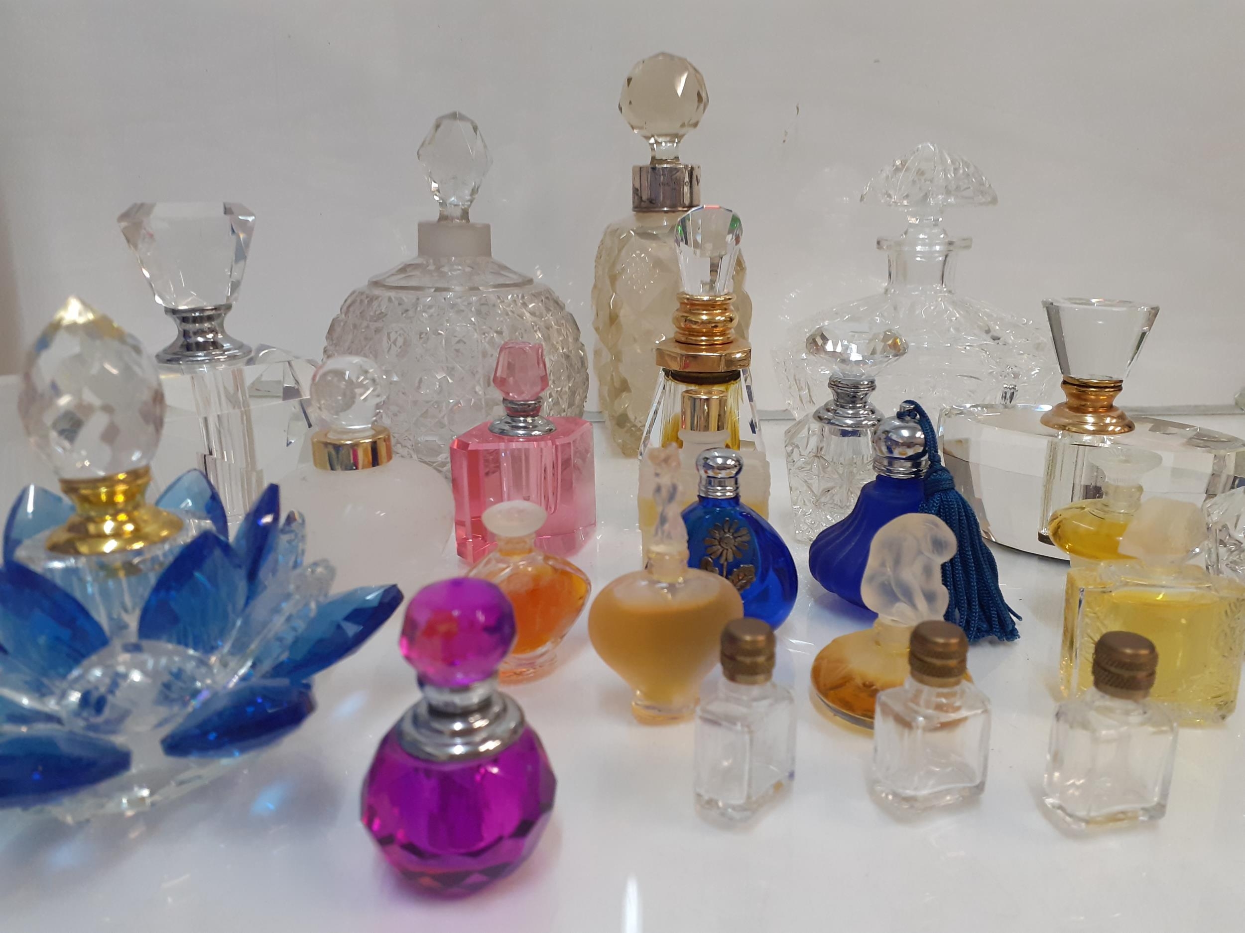 A collection of decorative empty glass perfume bottles to include a silver collared example and