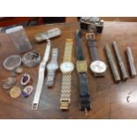 A 1930's gold plated watch on a leather strap, four other watches, vintage lighters, propelling