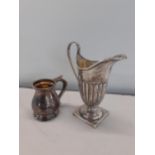 A small sterling silver pedestal jug and a small silver stub jug, together with two pendants