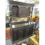 A late 19th century carved oak sideboard with coloured glass doors, figural supports, drawer and