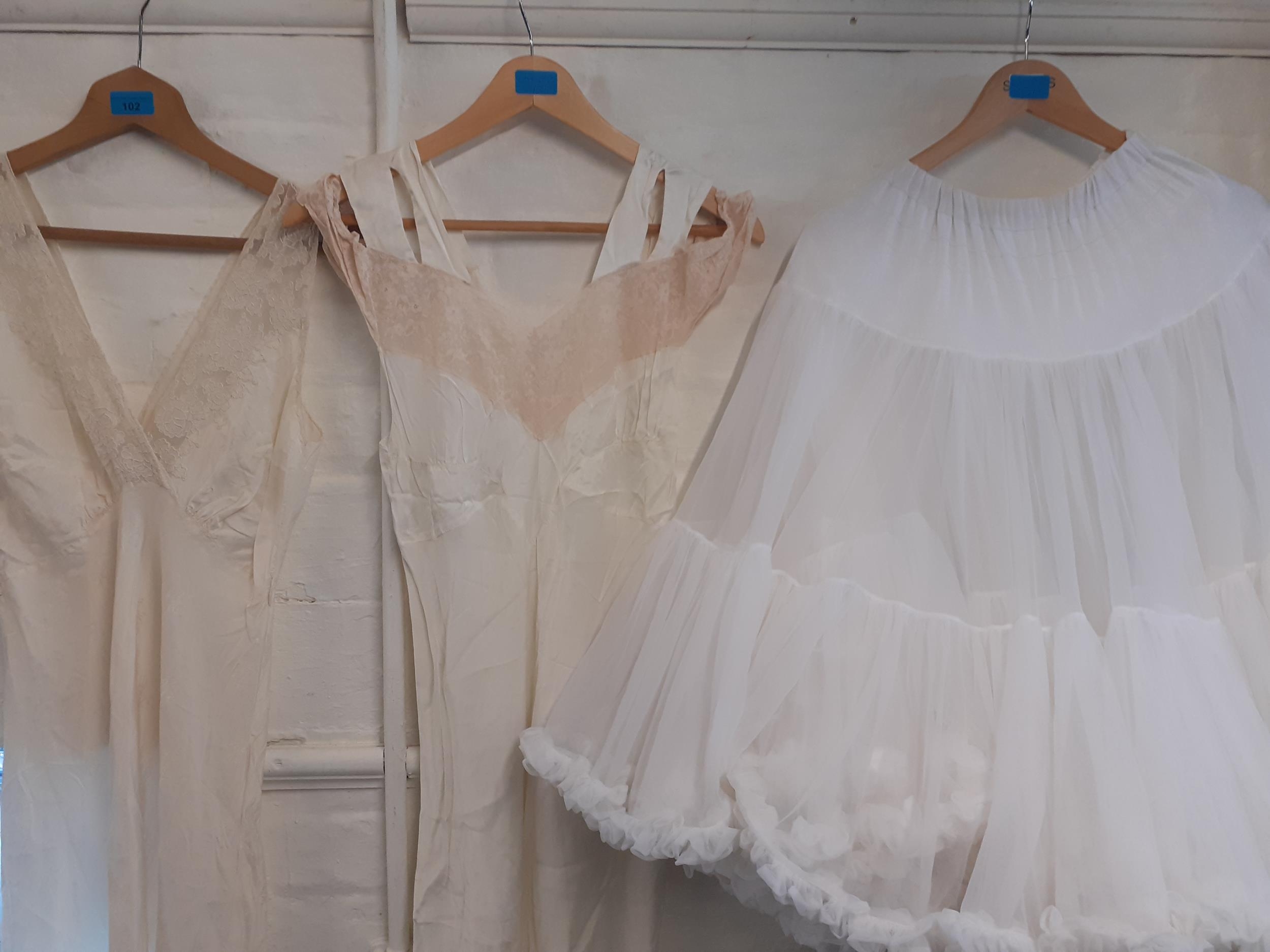 Two ladies cream and lace night gowns and a white tiered underskirt, size small Location: Rail