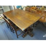 A 1930s Gammages oak refectory dining table on trestle ends, and a matching set of four carved