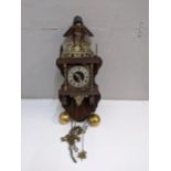 A reproduction of a Dutch wall clock with brass ornament and a pair of weights Location: G
