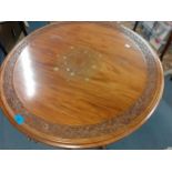 A carved topped drum table with brass inlay on ball and claw feet, Location: A3M