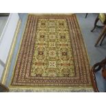 A hand woven green ground rug having floral motifs and multiguard borders, 182 x 124.5cm