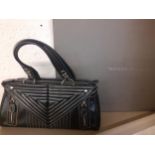 A Tanner Krolle black leather handbag with white stitching in a geometric fashion having silver tone