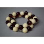 A Mixed Bead Necklace Comprising 17 Ivory Beads and 16 Faceted Amber Beads