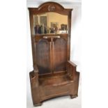 An Edwardian Oak Hall Stand with Shaped Mirror Above Small Shelf, Central Hinged Seat Store