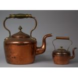 A Large Copper Kettle with Acorn Finial and Brass Loop Carrying Handle together with a Smaller