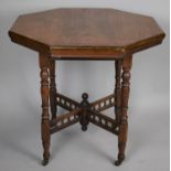 An Edwardian Mahogany Hexagonal Topped Table on Turned Caster Supports and Spindled Stretcher,