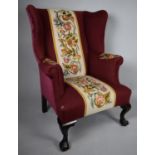 An Upholstered Wing Armchair with Georgian Shaped High Back and Supported on Front Claw Feet