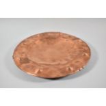 An Arts and Crafts Copper Hand Beaten Charger, 30cm Diameter