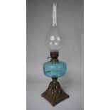 A Late Victorian Oil Lamp with Blue Glass Reservoir and Pierced Cast Iron Base Decorated with Fruit,