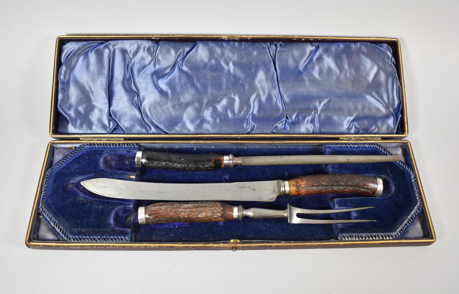 A Cased Silver Banded Three Piece Carving Set with Antler Handles by Walker & Hall, Sheffield 1934