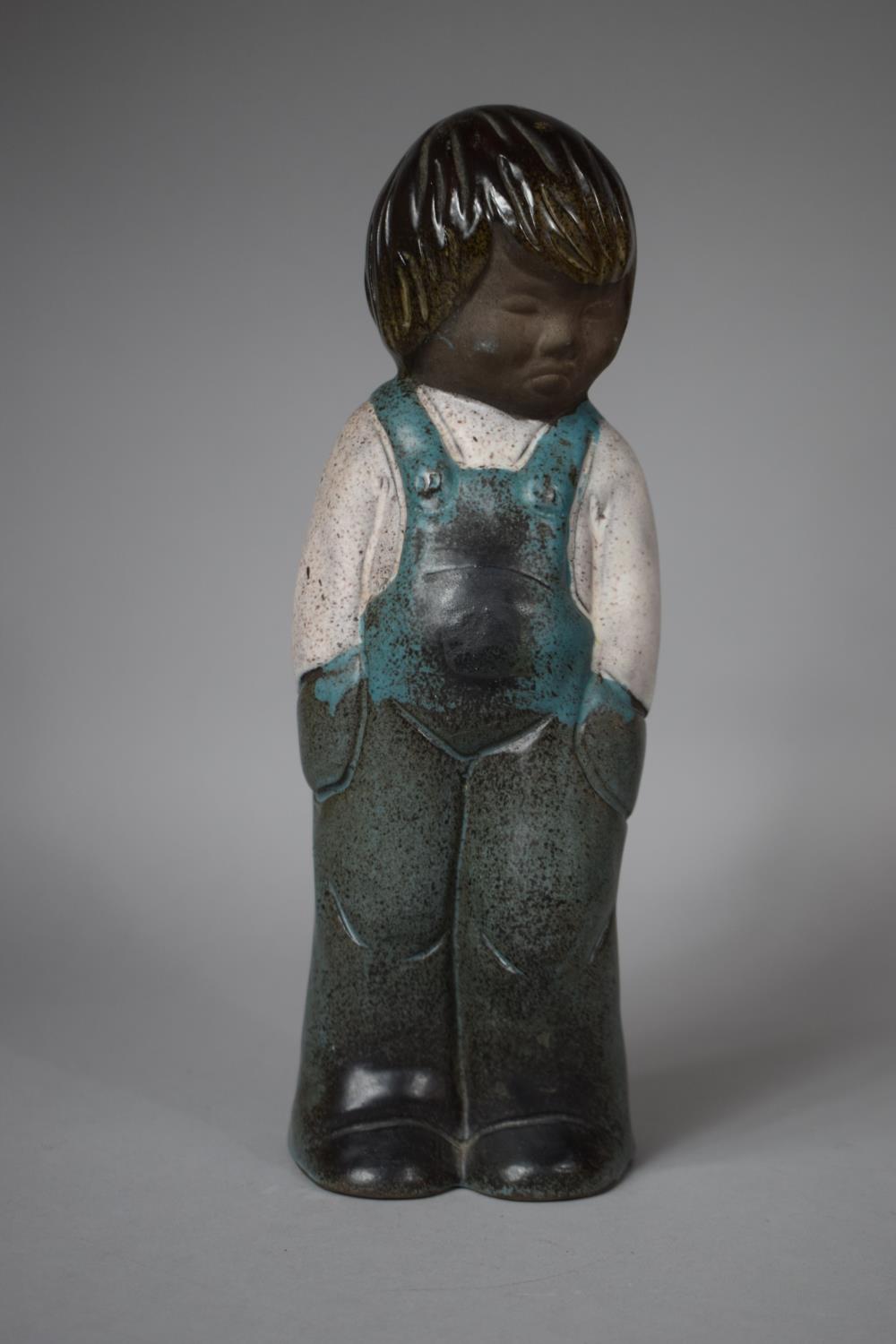 An Irish Glazed Stoneware Figure of a Child in Dungarees, 29.5cm high