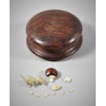 A Small Circular 19th Century Box Containing Tooth Carving Animals, Together with Miniature Seed Pod
