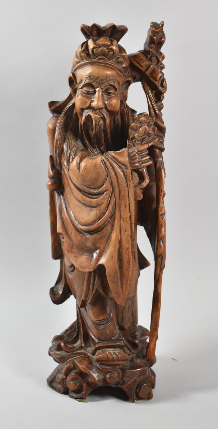 A Chinese Carved Wooden Study of Immortal with Staff Carrying Posy of Flowers, Some Attention Flaws,