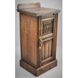 A Mid 20th Century Oak Galleried Bedside Cabinet with Carved and Panelled Door and Brass Handle,