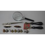 A Collection of Sundries to Include Magnifying Glass, Needles, Letter Opener, Thimbles etc