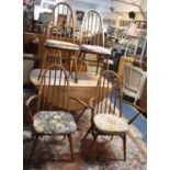 An Ercol Drop Leaf Oval Topped Dining Table, Somewhat Faded, Together with Four Hooped Back Dining