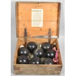 A Wooden Box Containing Eight Ebonised Lawn Balls and Two Jacks