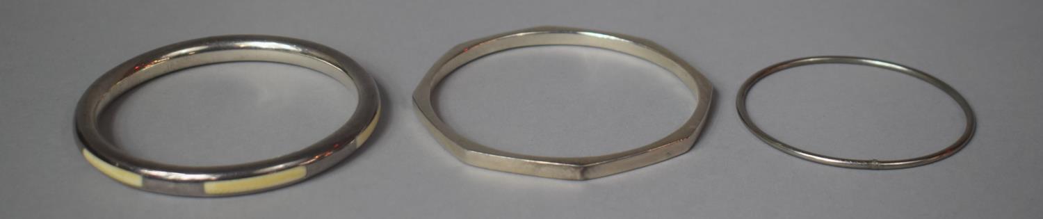 Two Silver Bangles Together with a White Metal Example