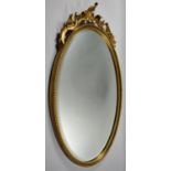 A Modern Gilt Framed Oval Wall Mirror with Bevel Glass and Shaped Finial, 66cm high
