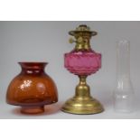 A 20th Century Brass Oil Lamp with Cranberry Glass Reservoir and Unrelated Shade and Chimney, Lamp