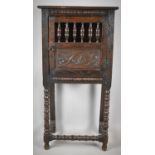 A Carved Oak Two Shelf Bread Cabinet with Panelled and Spindled Door on Bobbin Supports and