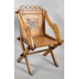 A Gothic Revival Oak Glastonbury Chair with Fleur De Lys Top Rail and Pierced Back Rest