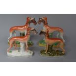 A Collection of Four Staffordshire Figures of Greyhounds Beside Tree Trunks with Hares in Mouths,