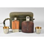 A Mid 20th Century Oval Leather Case Containing Two Hip Flasks and Two Silver Plated Cups, 22cm wide