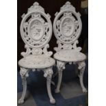 A Pair of White Painted Cast Metal Garden Patio Chair, the Oval Backrests Decorated with Farmer