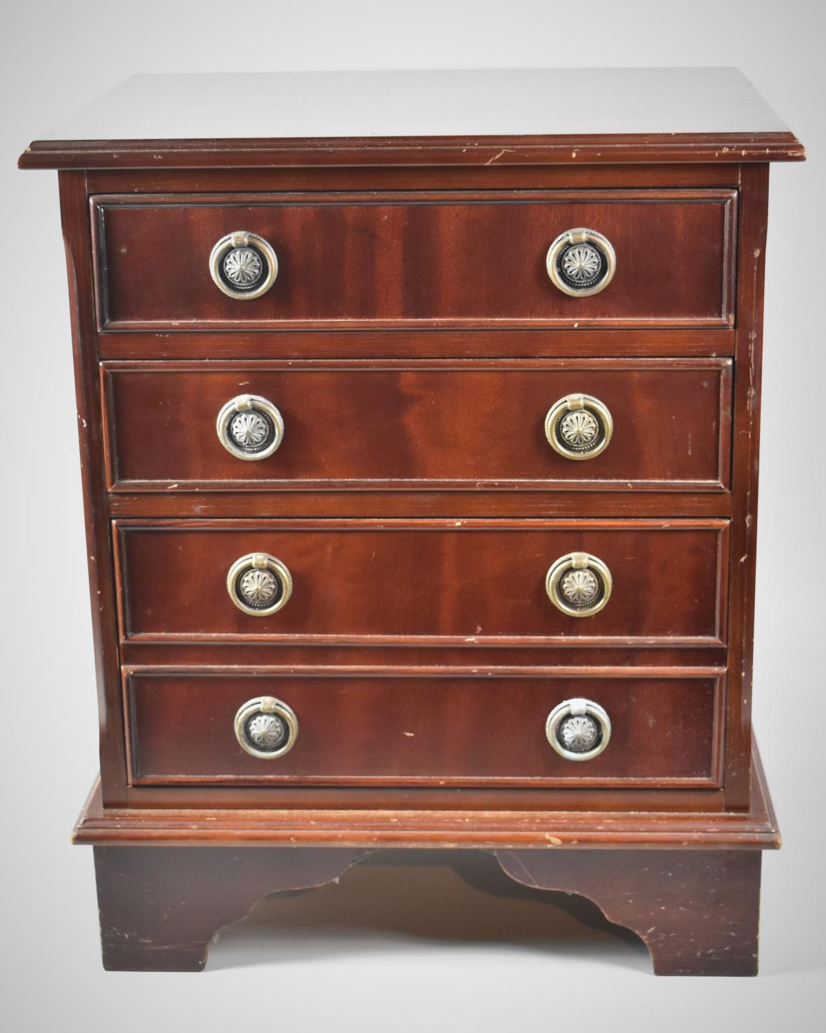 A Miniature Mahogany Four Drawer Chest with Circular Brass Drop Handles on Bracket Feet,