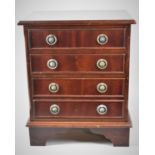 A Miniature Mahogany Four Drawer Chest with Circular Brass Drop Handles on Bracket Feet,