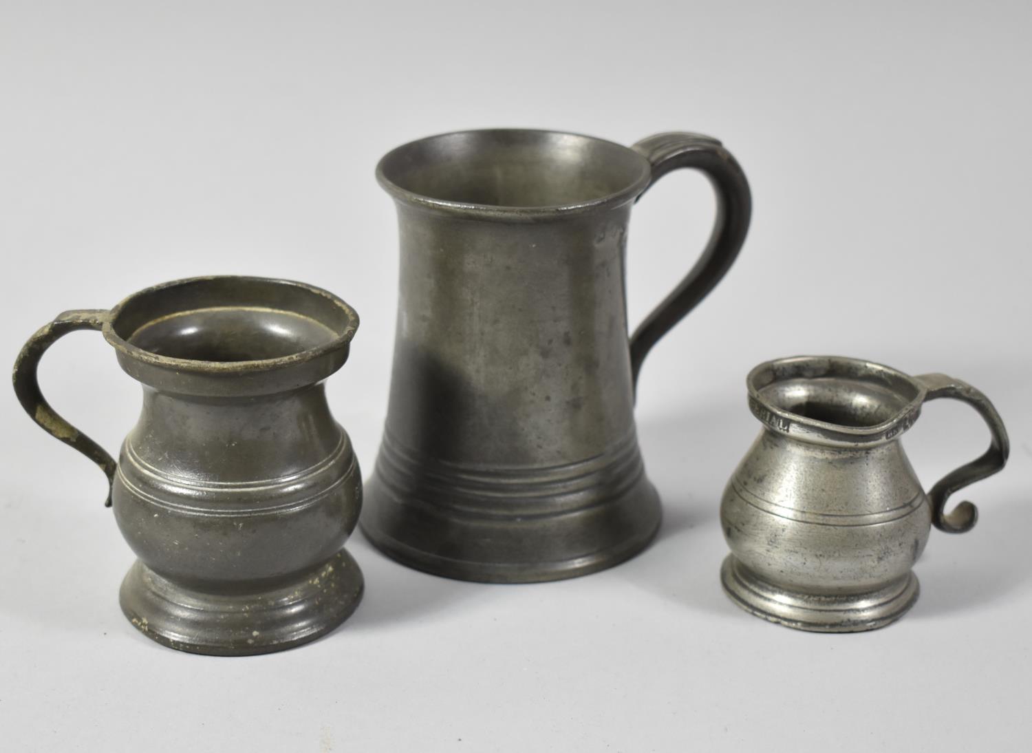 Two Graduated Pewter Measures Together with a Half Pint Glass Bottomed Pewter Tankard
