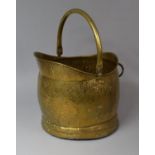A Hammered Brass Helmet Shaped Coal Scuttle with Loop Handle