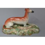 A Staffordshire Figure of a Reclining Greyhound with Hare on Natilistic Oval Base, 26.5cm Long