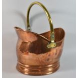 A Mid 20th Century Copper Helmet Shaped Coal Scuttle with Brass Loop Handle, 38cm high