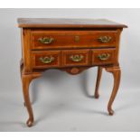 A Reproduction Crossbanded Walnut and Mahogany Lowboy Having Long Centre Drawer Over Three Short