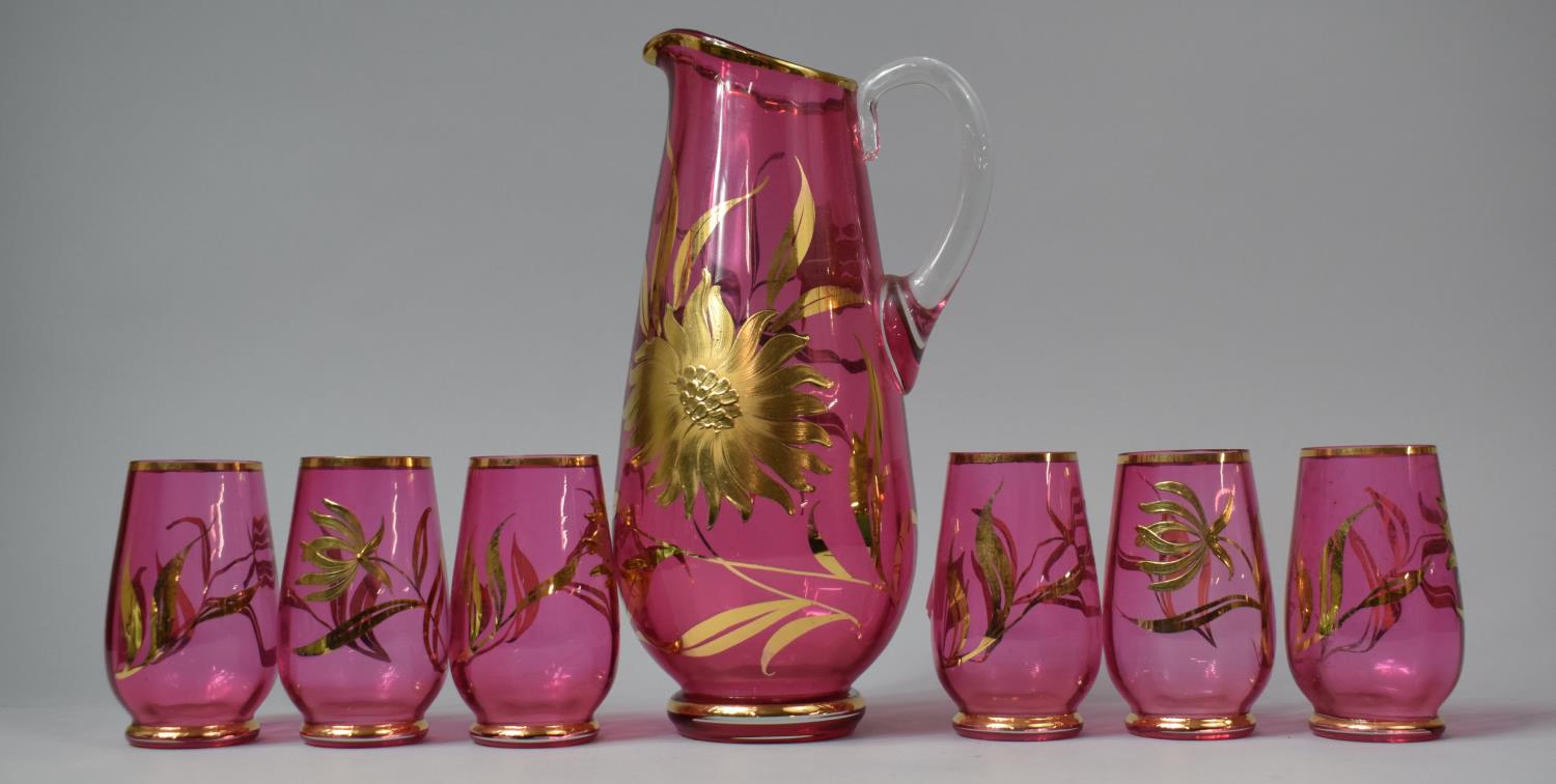 A Modern Cranberry Jug and Six Tumbler Set Decorated with Gilt Flowers