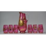 A Modern Cranberry Jug and Six Tumbler Set Decorated with Gilt Flowers