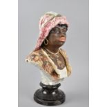 A Continental Ceramic Bust of an African Lady with Necklace, on Turned Socle, 36cm High