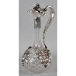 A Large Glass Globe and Stalk Claret Jug with White Metal Mounts in the Form of Vines and Leaves,