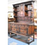 An Edwardian Oak Dresser, the base with Two Fielded Geometric Drawers Over Cupboard, Raised Black