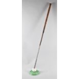 A Cast Iron Novelty Stand in the Form of a Golf Ball on Green and Used to Support Golf Iron Poker