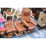 A Tan Leather "Stressless" Armchair by Ekornes Together with Two Matching Footstools