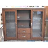 A Modern Glazed Cabinet with Open Storage Space Over Two Short Drawer Flanked by Glazed Door to