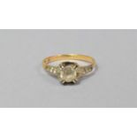 A Stamped Yellow Metal Ladies Dress Ring with Solitaire White Stone and Chips to Shoulder