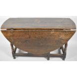 A Mid 19th Century Oak Oval Topped Drop Leaf Gate Legged Dining Table, on Turned Supports with